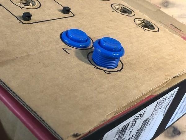 Two buttons squeezed into cardboard holes